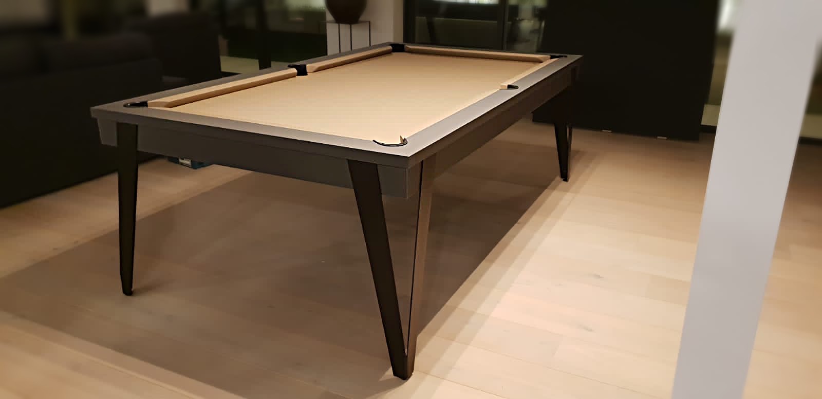 billard élégant au design sobre et moderne finition nano graphite encadrant un jeu au tissu taupe posé sur des pieds en métal noir d'une extrême finesse